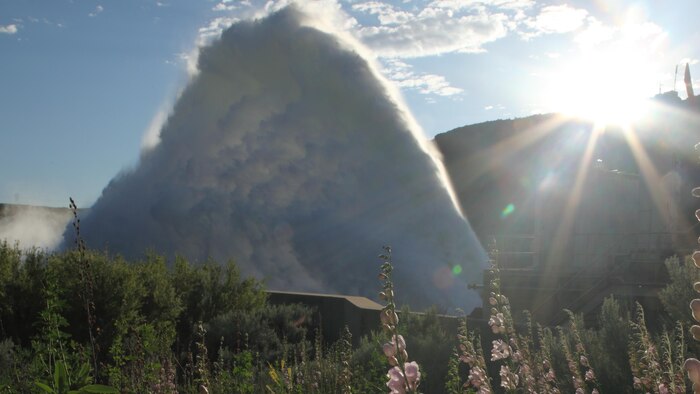 View of the "Rooster Tail", Lucky Peak Dam, June 12, 2010, Boise, Idaho. A popular springtime attraction is the "Rooster Tail" which results from the discharge of water through the original release structures of the dam under pressure from the lake above.  Using a "flip bucket" to direct the spray high into the air, the erosive, scouring force of the water is greatly dissipated as it rises, rests and slowly falls back to the stream channel.
The Rooster Tail only uses water from large releases required for flood risk management that exceed powerhouse capacity, thus no water is wasted for the display.   
It occurred daily until 1986 when construction of the Lucky Peak Power Plant Project started.  
