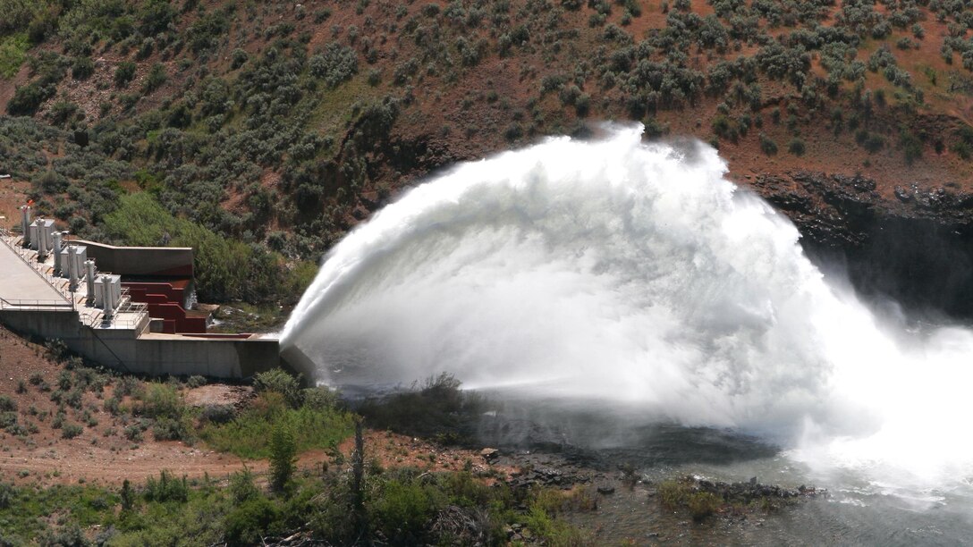 A view of the "Rooster Tail", from Lucky Peak Dam, Boise, Idaho, May 25, 2008. It is popular springtime attraction is the "Rooster Tail" which results from the discharge of water through the original release structures of the dam under pressure from the lake above.  Using a "flip bucket" to direct the spray high into the air, the erosive, scouring force of the water is greatly dissipated as it rises, rests and slowly falls back to the stream channel.
The Rooster Tail only uses water from large releases required for flood risk management that exceed powerhouse capacity, thus no water is wasted for the display.   
It occurred daily until 1986 when construction of the Lucky Peak Power Plant Project started.  
