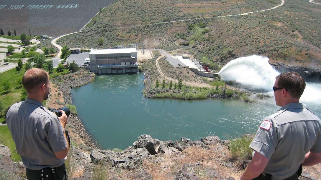 U.S. Army Corps of Engineers rangers observe "Rooster Tail" outflows from Lucky Peak Dam, near Boise, Idaho, May 25, 2008. The "Rooster Tail" which results from the discharge of water through the original release structures of the dam under pressure from the lake above.  Using a "flip bucket" to direct the spray high into the air, the erosive, scouring force of the water is greatly dissipated as it rises, rests and slowly falls back to the stream channel. The Rooster Tail only uses water from large releases required for flood risk management that exceed powerhouse capacity, thus no water is wasted for the display.   
