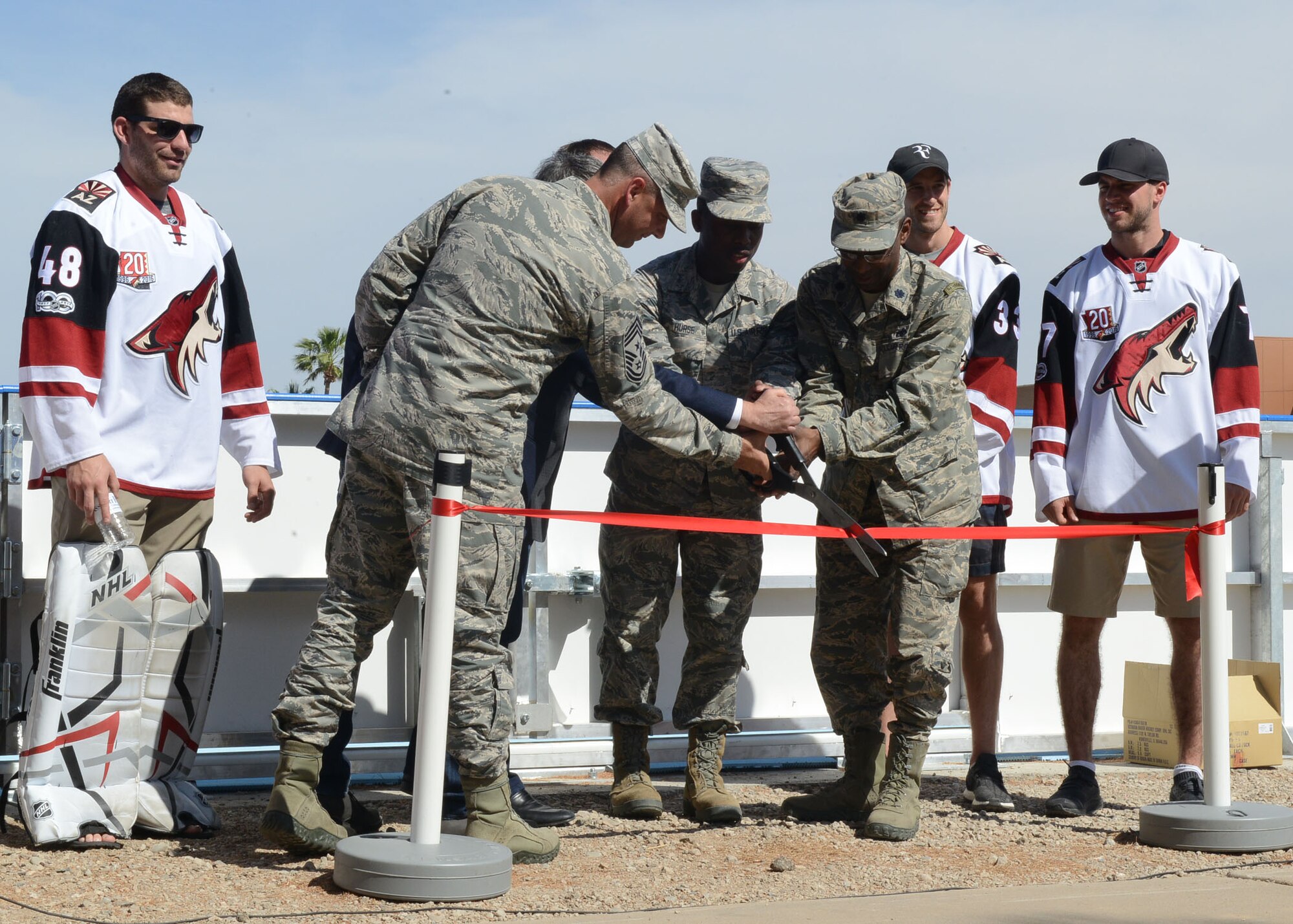 Lt. Col. Kevin Marzette, 56th Mission Support Group deputy commander, and Chief Master Sgt. Randall Kwiatkowski, 56th Fighter Wing command chief, cut the ribbon signifying the opening of the deck hockey rink April 13, 2017, at Luke Air Force Base, Ariz. The Arizona Coyotes attended the ceremony and held a skills clinic for Airmen afterwards. (U.S. Air Force photo by Senior Airman James Hensley)