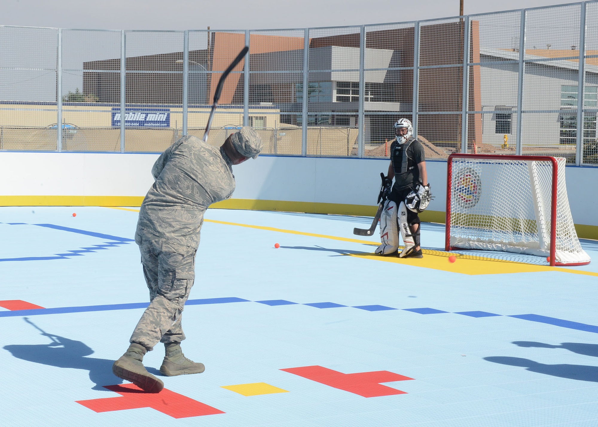 A Thunderbolt takes a shot against an Arizona Coyotes player after the ribbon cutting ceremony for the new hockey rink April 13, 2017, at Luke Air Force Base, Ariz. The rink is located adjacent to the base pool and Community Commons. (U.S. Air Force photo by Senior Airman James Hensley)