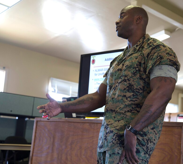 Maj. Jason Schneider, Commanding Officer for H&S Co., H&S Bn., MCI West - MCB Camp Pendleton, paces through an aisle whilst giving a brief on the Marine Corps Policy on social media April 13, 2017. Briefs like these are conducted to ensure that Marines stay up to date on all of the current Marine Corps Policies and regulations. (U. S. Marine Corps Photo by LCpl. Dylan Chagnon) levels adjusted and image cropped to highlight the subject.