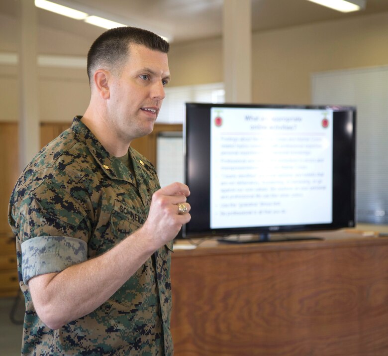 Maj. Jason Schneider, Commanding Officer for H&S Co., H&S Bn., MCI West - MCB Camp Pendleton, paces through an aisle whilst giving a brief on the Marine Corps Policy on social media April 13, 2017. Briefs like these are conducted to ensure that Marines stay up to date on all of the current Marine Corps Policies and regulations. (U. S. Marine Corps Photo by LCpl. Dylan Chagnon) levels adjusted and image cropped to highlight the subject.