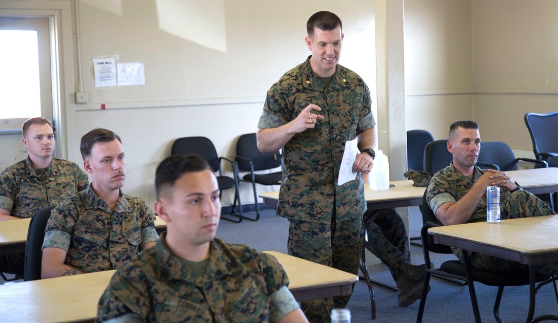 Maj. Jason Schneider, Commanding Officer for H&S Co., H&S Bn., MCI West - MCB Camp Pendleton, paces through an aisle whilst giving a brief on the Marine Corps Policy on social media April 13, 2017. Briefs like these are conducted to ensure that Marines stay up to date on all of the current Marine Corps Policies and regulations. (U. S. Marine Corps Photo by LCpl. Dylan Chagnon) levels adjusted and image cropped to highlight the subject.