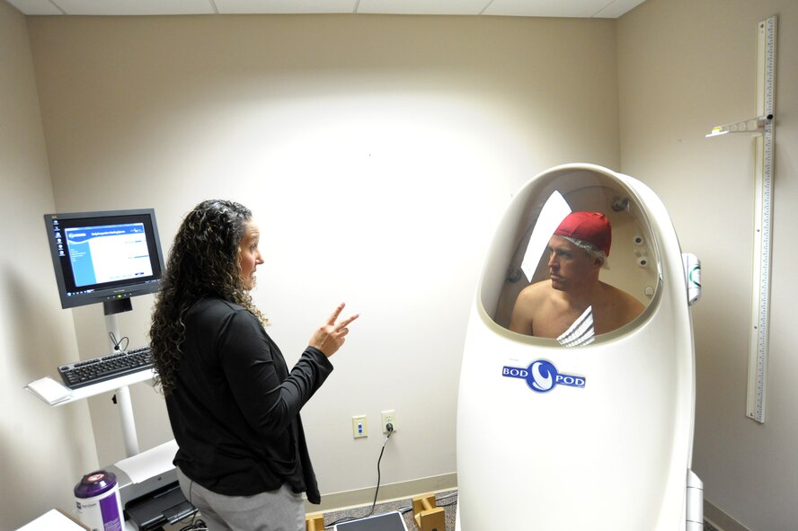 Aracelis Gonzalez-Anderson, 359th Medical Group, health promotions program coordinator, checks Lt Col Dave Youngdale, body composition by placing him in the Bod Pod, April 12, at Joint Base San Antonio-Randolph.  The BOD POD is an air displacement plethysmograph that determines bod composition, distinguishing fat versus lean muscle mass.  