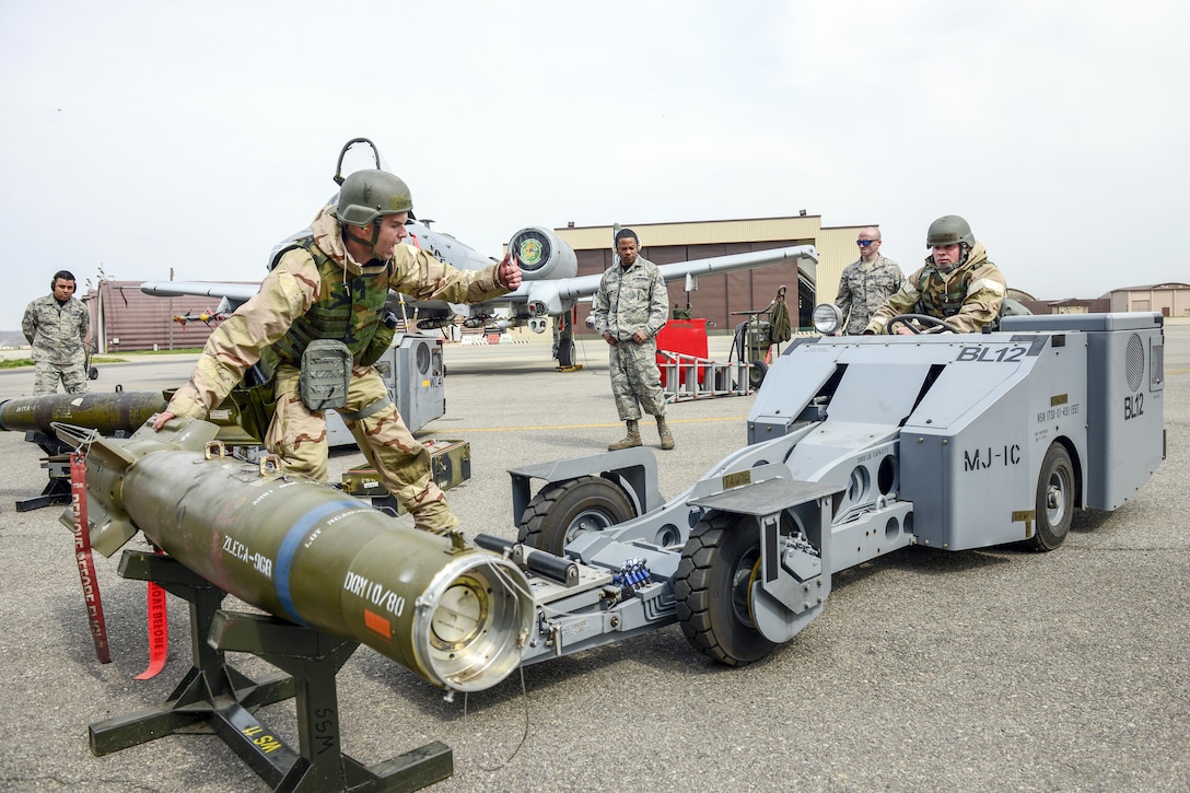 Air Force Staff Sgt. John Bybee guides Staff Sgt. Andrew Finnegan as they move a GBU-12 Paveway II bomb during a weapons load crew competition at Osan Air Base, South Korea, April 14, 2017. The airmen, assigned to the New Jersey Air National Guard's 177th Fighter Wing, competed against active-duty counterparts. Air Force photo by Staff Sgt. Victor J. Caputo