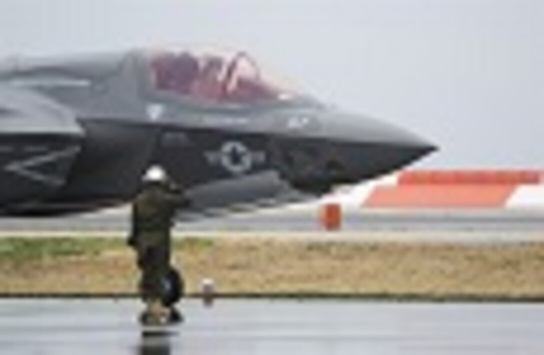 A U.S. Marine with Marine Fighter Attack Squadron (VMFA) 121 salutes a pilot during hot-reload training at Marine Corps Air Station Iwakuni, Japan, April 6, 2017. This signified the first time the squadron loaded ordnance onto a running F-35B Lightning II aircraft at the air station in order to prepare for real-world scenarios. 