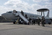 Aircrew from the 961st Airborne Air Control Squadron step onto an E-3 Sentry March 28, 2017, at Kadena Air Base, Japan. The Sentry has rotating radar with a range of more than 250 miles, providing early warning and detection for missions. (U.S. Air Force photo by Senior Airman John Linzmeier/released)