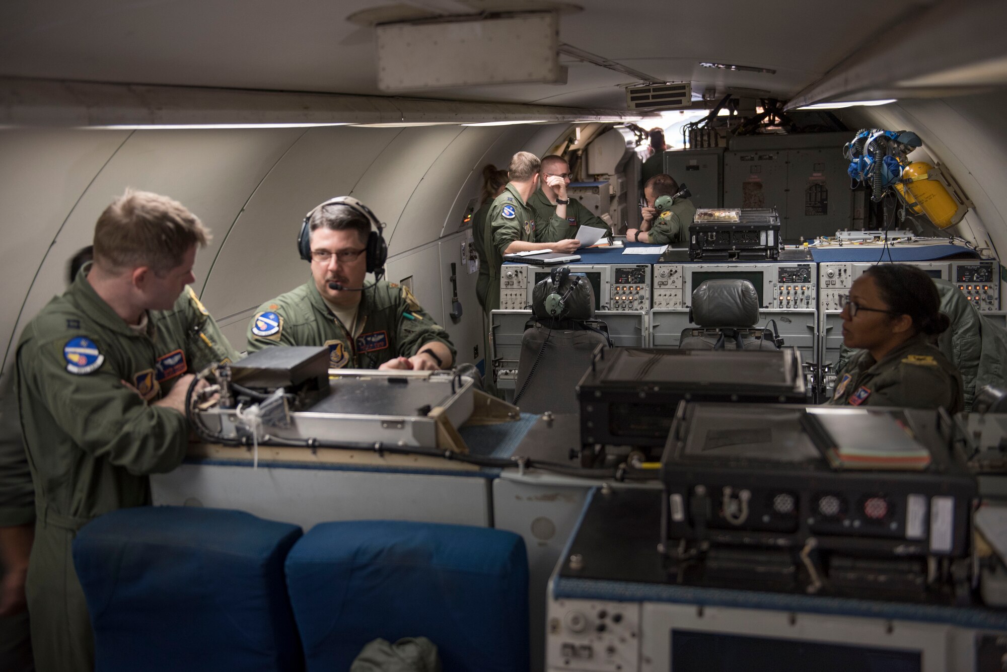 U.S. Air Force Airman 1st Class Favian Arteaga, 961st Airborne Air Control Squadron airborne surveillance technician (left), uses a communication system March 28, 2017, while flying in an E-3 Sentry over the Pacific Ocean. Airborne surveillance technicians make the initial identification of friend or foe aircraft and monitor their position. (U.S. Air Force photo by Senior Airman John Linzmeier/released)