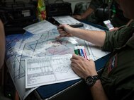 A U.S. Air Force air weapons officer from the 961st Airborne Air Control Squadron plans out a training combat scenario March 28, 2017, while flying in an E-3 Sentry over the Pacific Ocean. As an air defense system, the Sentry can detect, identify and track airborne enemy forces far from the boundaries of the United States or NATO countries. (U.S. Air Force photo by Senior Airman John Linzmeier/released)