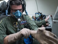 U.S. Air Force Maj. Matthew Starck, 961st Airborne Air Control Squadron mission crew commander, dawns individual protective gear for a rapid depressurization drill March 28, 2017, while flying in an E-3 Sentry over the Pacific Ocean. Aircrew members are constantly being tested on how to react in emergency scenarios during training operations. (U.S. Air Force photo by Senior Airman John Linzmeier/released)