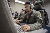 U.S. Air Force Airman 1st Class Favian Arteaga, 961st Airborne Air Control Squadron airborne surveillance technician, uses a communication system March 28, 2017, while flying in an E-3 Sentry over the Pacific Ocean. Surveillance technicians detect, track and identify friendly and enemy aircraft and forward all relevant information to the airborne air control system controller team. (U.S. Air Force photo by Senior Airman John Linzmeier/released)