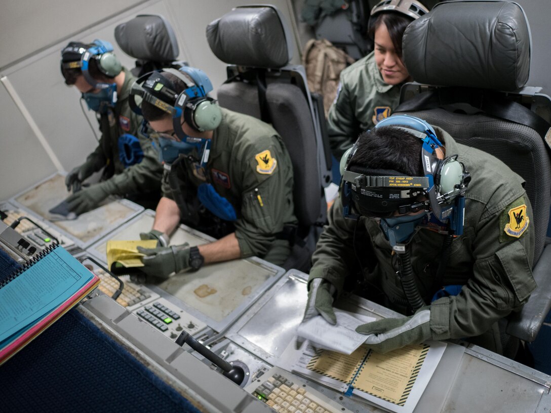 U.S. Air Force 961st Airborne Air Control Squadron airborne surveillance technicians conduct a crew coordination drill March 28, 2017, while flying in an E-3 Sentry over the Pacific Ocean. The team was evaluated as they went over emergency procedures and continued their job in a simulated depressurized atmosphere. (U.S. Air Force photo by Senior Airman John Linzmeier/released)