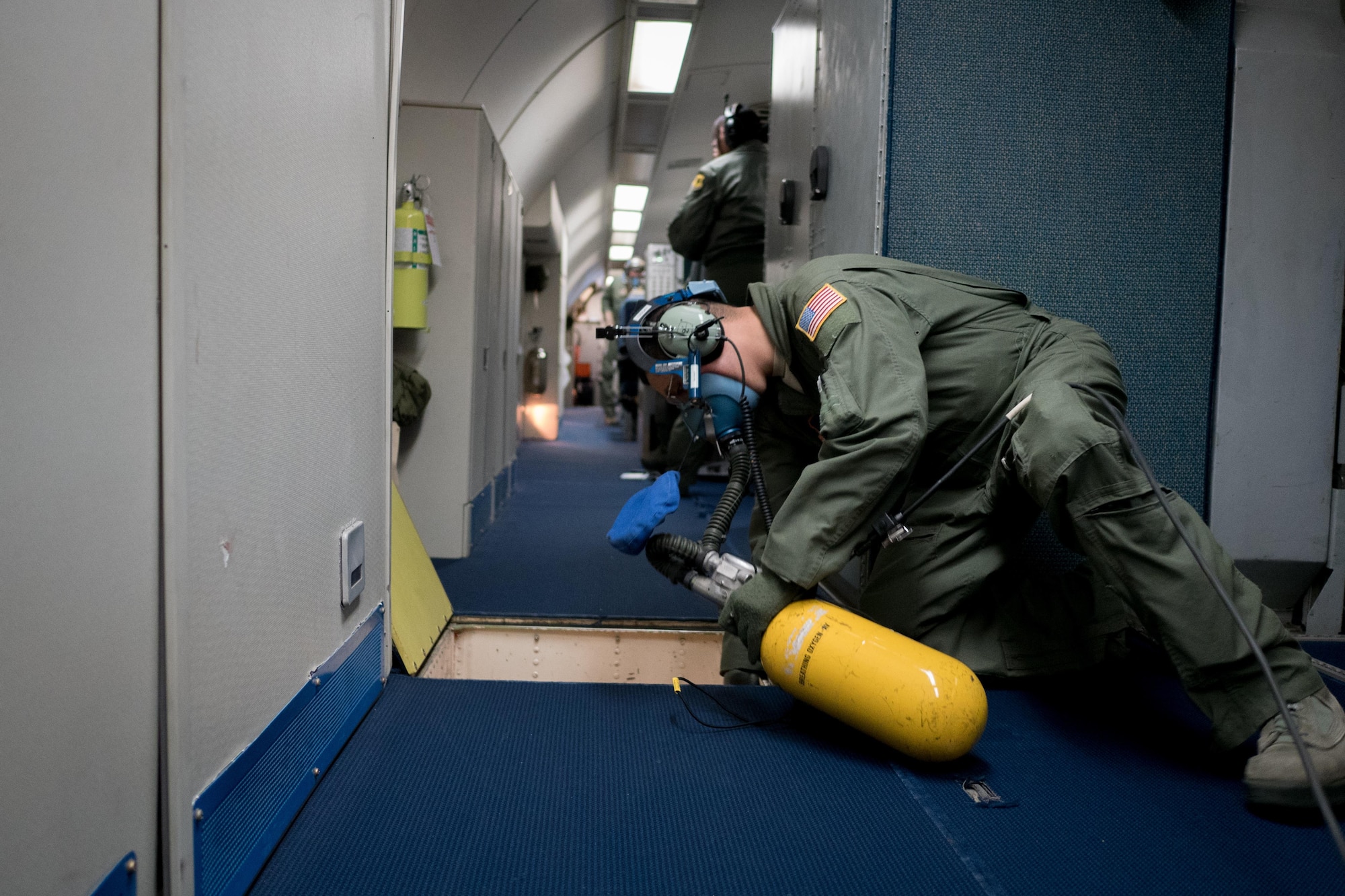 U.S. Air Force Staff Sgt. Anthony Aranda, 961st Airborne Air Control Squadron air radar technician, inspects an E-3 Sentry aircraft for damage during a rapid depressurization drill March 28, 2017, while flying over the Pacific Ocean. Radar technicians can take on various roles, such as a fire fighter, within the mission crew area in the event of an emergency. (U.S. Air Force photo by Senior Airman John Linzmeier/released)