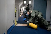 U.S. Air Force Staff Sgt. Anthony Aranda, 961st Airborne Air Control Squadron air radar technician, inspects an E-3 Sentry aircraft for damage during a rapid depressurization drill March 28, 2017, while flying over the Pacific Ocean. Radar technicians can take on various roles, such as a fire fighter, within the mission crew area in the event of an emergency. (U.S. Air Force photo by Senior Airman John Linzmeier/released)