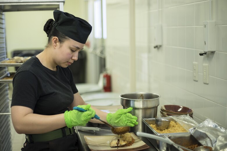 Lance Cpl. Erika Vargas, a food service specialist with Headquarters and Headquarters Squadron, prepares a dish during a Food Service Specialist of the Quarter competition at Marine Corps Air Station Iwakuni, Japan, April 13, 2017. The Food Service Specialist of the Quarter is a long-standing tradition within the Marine Corps food service community. The program is designed to allow food service Marines to showcase and demonstrate their individual culinary skills. (U.S. Marine Corps photo by Lance Cpl. Joseph Abrego)