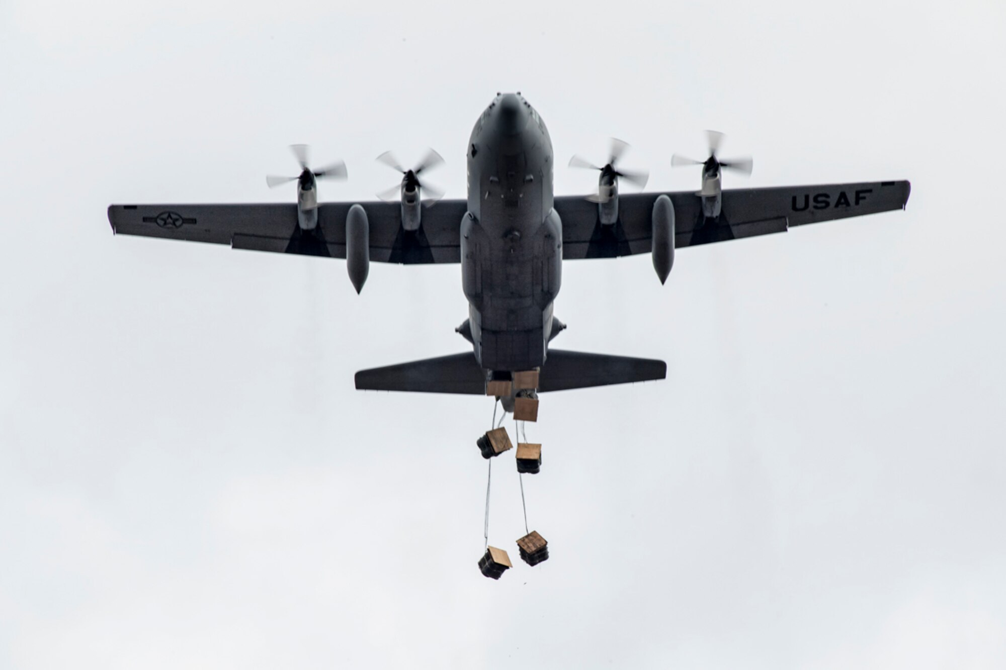 Airmen inside a C-130H Hercules assigned to the 36th Airlift Squadron drops containerized delivery system bundles at Combined Armed Training Center Camp Fuji, Japan, April 12, 2017. Airmen from the 374th Logistics Readiness Squadron and Eagle airlifts with the 36th AS conducted mass CDS airdrop training. (U.S. Air Force photo by Yasuo Osakabe)
