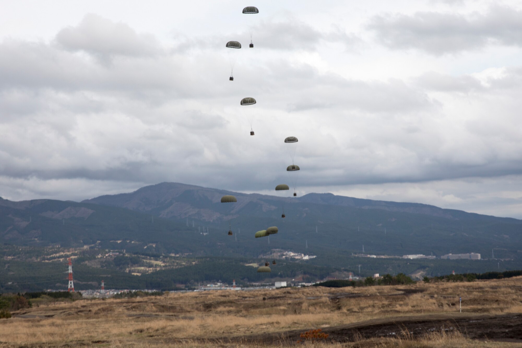 Containerized Delivery System bundles drop on a drop zone at Combined Armed Training Center Camp Fuji, Japan, April 12, 2017, during a training mission. Airmen with the 374th Logistics Readiness Squadron and Eagle airlifts with the 36th Airlift Squadron conducted mass CDS airdrop training. (U.S. Air Force photo by Yasuo Osakabe)