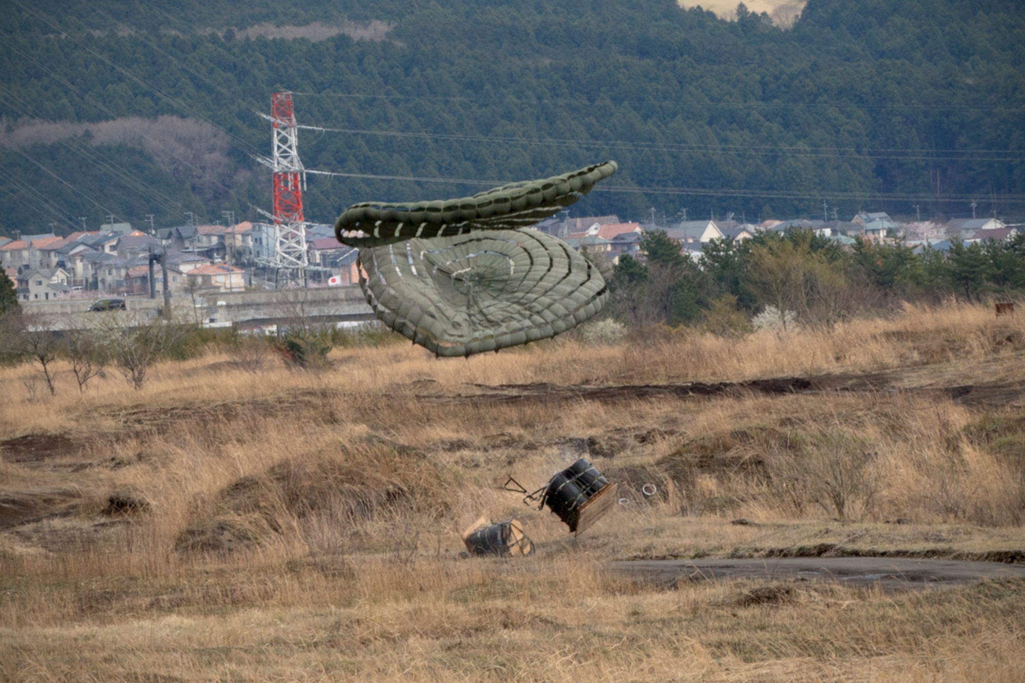 Containerized delivery system bundles drop on a drop zone at Combined Armed Training Center Camp Fuji, Japan, April 12, 2017, during a training mission. Airmen from the 374th Logistics Readiness Squadron and Eagle airlifts with the 36th Airlift Squadron conducted mass CDS airdrop training. (U.S. Air Force photo by Yasuo Osakabe)