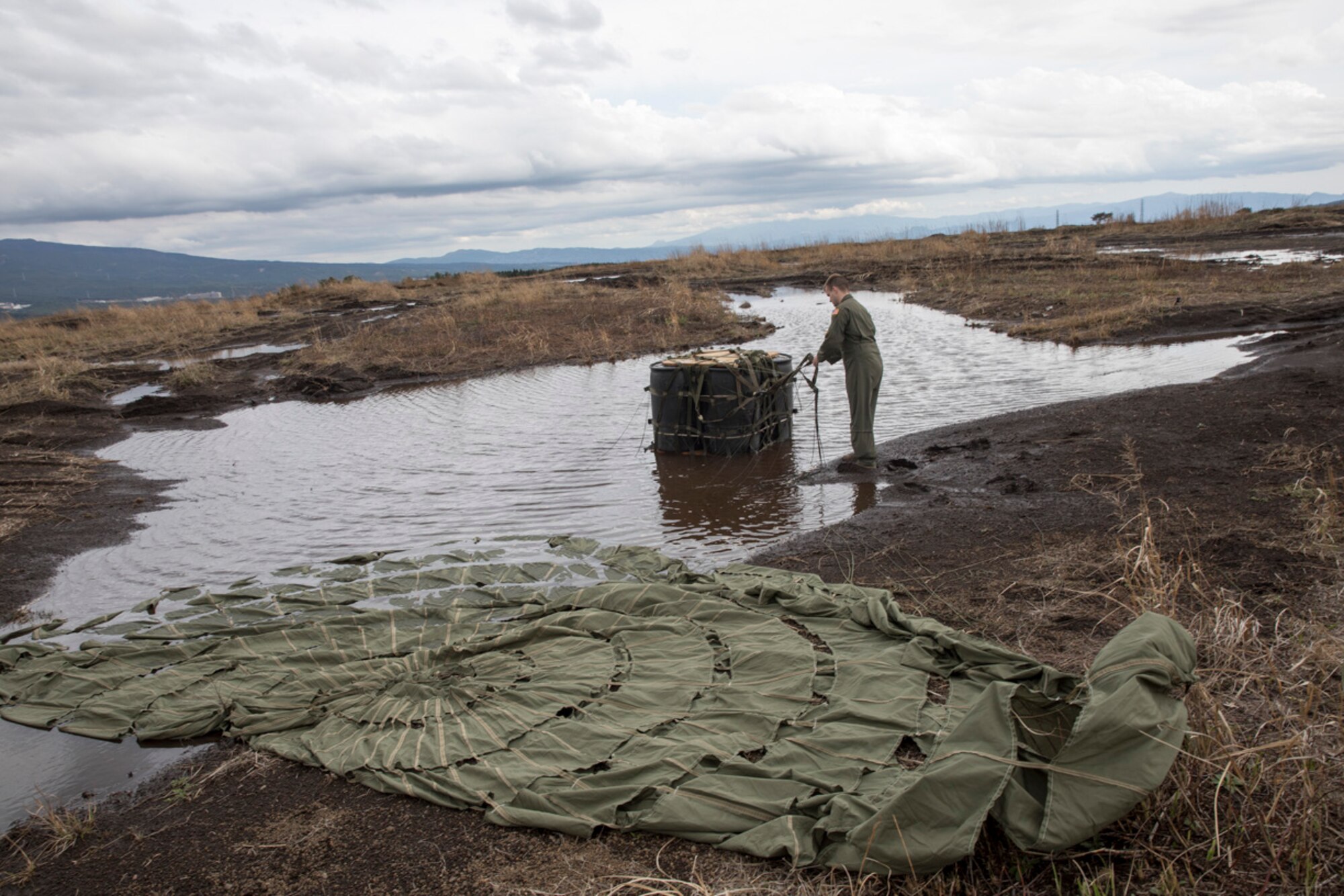 Airman 1st Class Stephen Clark, 36th Airlift Squadron C-130H loadmaster, recovers a containerized delivery system bundle from a water at Combined Armed Training Center Camp Fuji, Japan, April 12, 2017. Airmen with the 374th Logistics Readiness Squadron and Eagle airlifts with the 36th Airlift Squadron conducted mass CDS airdrop training. (U.S. Air Force photo by Yasuo Osakabe)