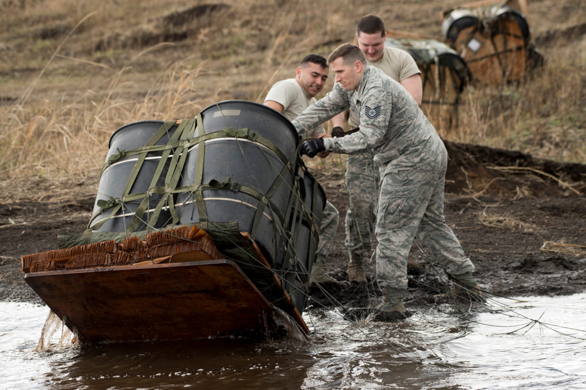 (Right to left) Staff Sgt. William McAtee, Tech Sgt. Daniel Blair, and Airman 1st Class Dominic Pacheco, all with the 374th Logistics Readiness Squadron combat mobility flight recovery team, pull a containerized delivery system bundle from a water at Combined Armed Training Center Camp Fuji, Japan, April 12, 2017. Airmen with the 374th Logistics Readiness Squadron and Eagle airlifts with the 36th Airlift Squadron conducted mass CDS airdrop training. (U.S. Air Force photo by Yasuo Osakabe)