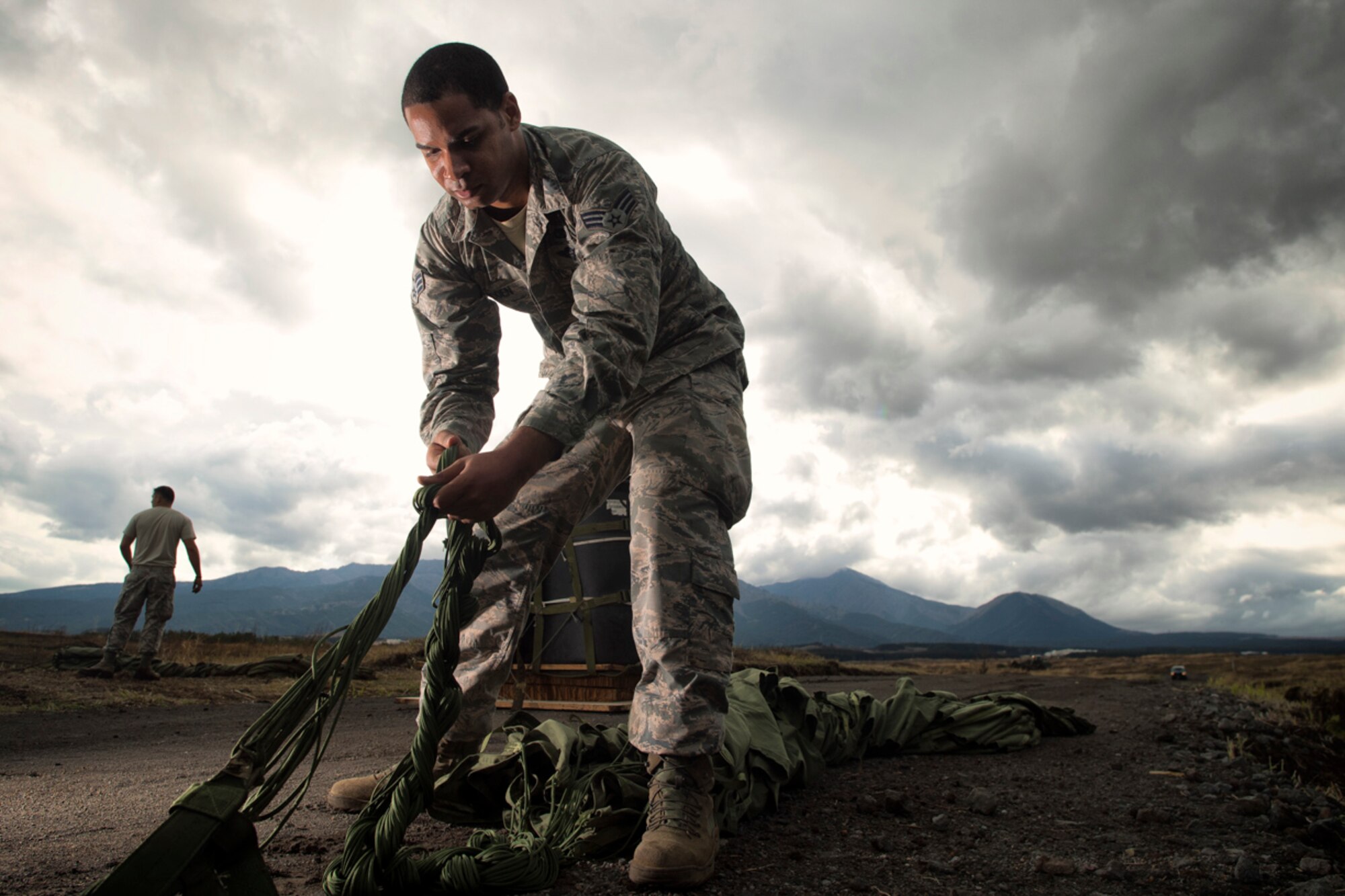 Senior Airman Brandon Roden, 374th Logistics Readiness Squadron combat mobility flight recovery specialist, recovers a parachute at Combined Armed Training Center Camp Fuji, Japan, April 12, 2017. Airmen with the 374th Logistics Readiness Squadron and Eagle airlifts with the 36th Airlift Squadron conducted mass CDS airdrop training. (U.S. Air Force photo by Yasuo Osakabe)