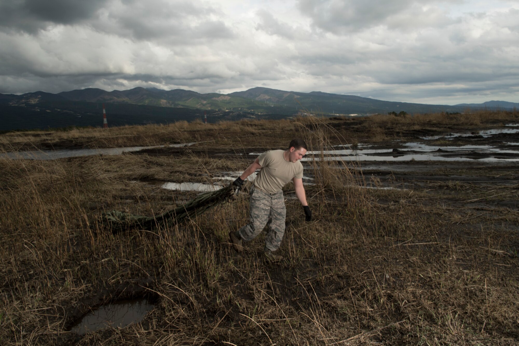 Staff Sgt. William McAtee, 374th Logistics Readiness Squadron combat mobility flight recovery team, carries an equipment parachute at Combined Armed Training Center Camp Fuji, Japan, April 12, 2017. Airmen with the 374th Logistics Readiness Squadron and Eagle airlifts with the 36th Airlift Squadron conducted mass CDS airdrop training. (U.S. Air Force photo by Yasuo Osakabe)