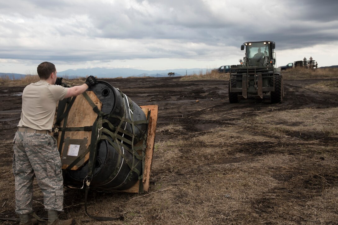 Staff Sgt. William McAtee, 374th Logistics Readiness Squadron combat mobility flight recovery specialist, waits for load a containerized delivery system bundle at Combined Armed Training Center Camp Fuji, Japan, April 12, 2017. Airmen with the 374th Logistics Readiness Squadron and Eagle airlifts with the 36th Airlift Squadron conducted mass CDS airdrop training. (U.S. Air Force photo by Yasuo Osakabe)