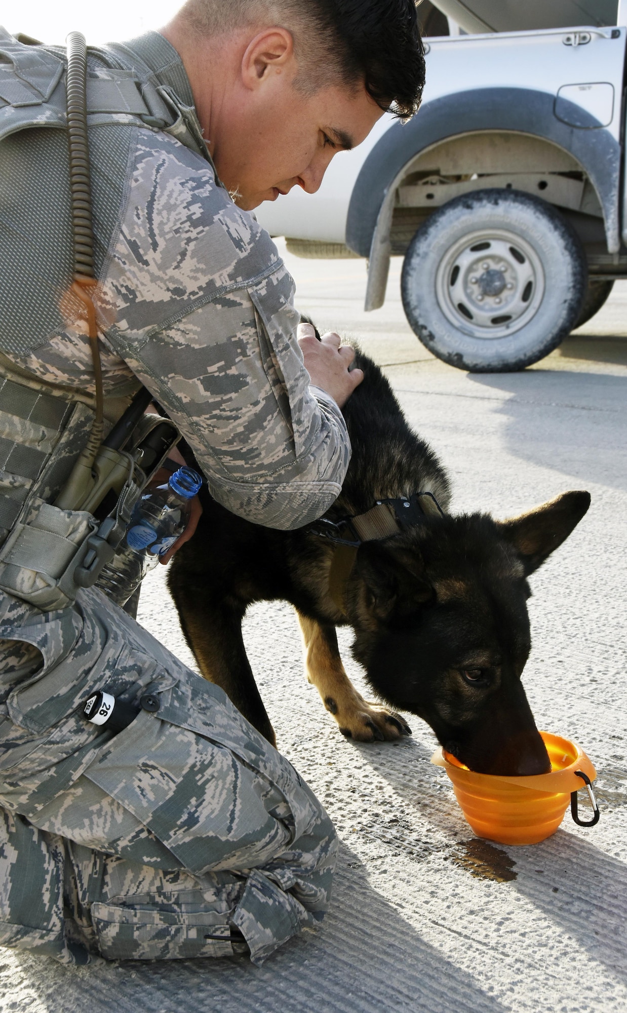 U.S. Air Force Staff Sgt. Dustin Braddy, a military working dog handler with the 379th Expeditionary Security Forces Squadron, gives his military working dog Jimo water after detection training on an aircraft at Al Udeid Air Base, Qatar, April 15, 2017. Braddy and Jimo are one of several military working dog teams here supporting Operation Inherent Resolve. (U.S. Air Force photo by Senior Airman Cynthia A. Innocenti)