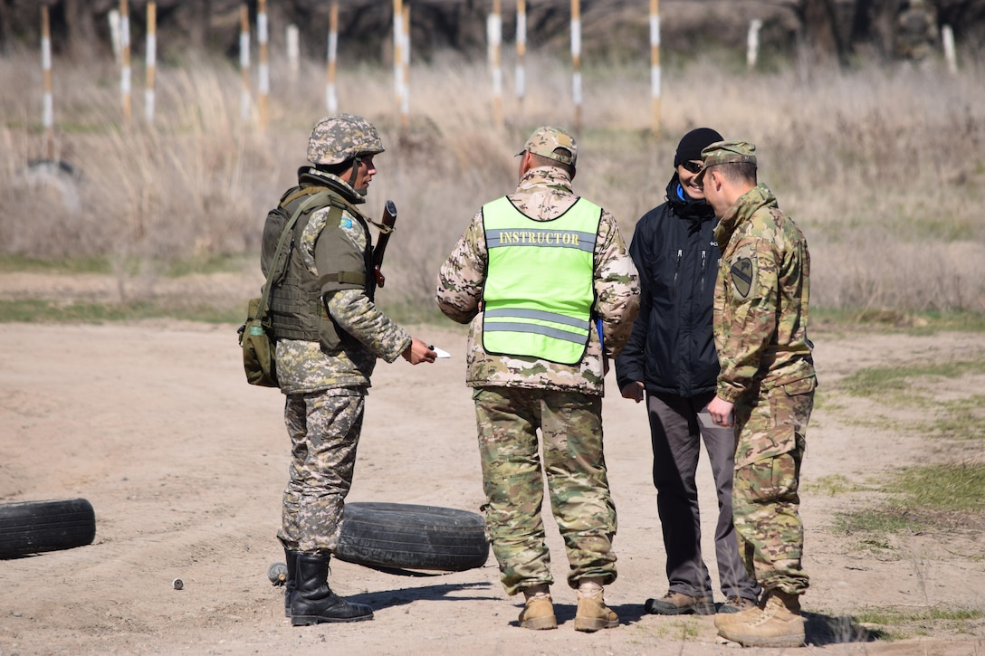 A Kazakhstani instructor from the Kazakhstan Peacekeeping Battalion, center, and an observer from the U.S. Army, right, hand a casualty card to a Kazakhstani soldier during a scenario for Steppe Eagle Koktem Apr. 10, 2017, at Illisky Training Center, Kazakhstan.