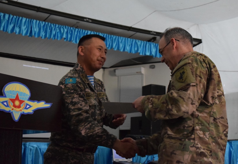 Lt. Col. Bulat Dusembayev, commander of the Kazakhstan Peacekeeping Brigade, left, presents Lt. Col. James Becker, 352nd Civil Affairs Command, with a certificate of appreciation during the closing day of Steppe Eagle Koktem, Apr. 11, 2017, at Illisky Training Center, Kazakhstan.