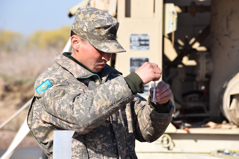 A soldier with the Kazakhstan Peacekeeping Battalion tests the level of chlorine in a beaker of purified water during a peacekeeping operations scenario for Steppe Eagle Koktem Apr. 9, 2017, at Illisky Training Center, Kazakhstan.
