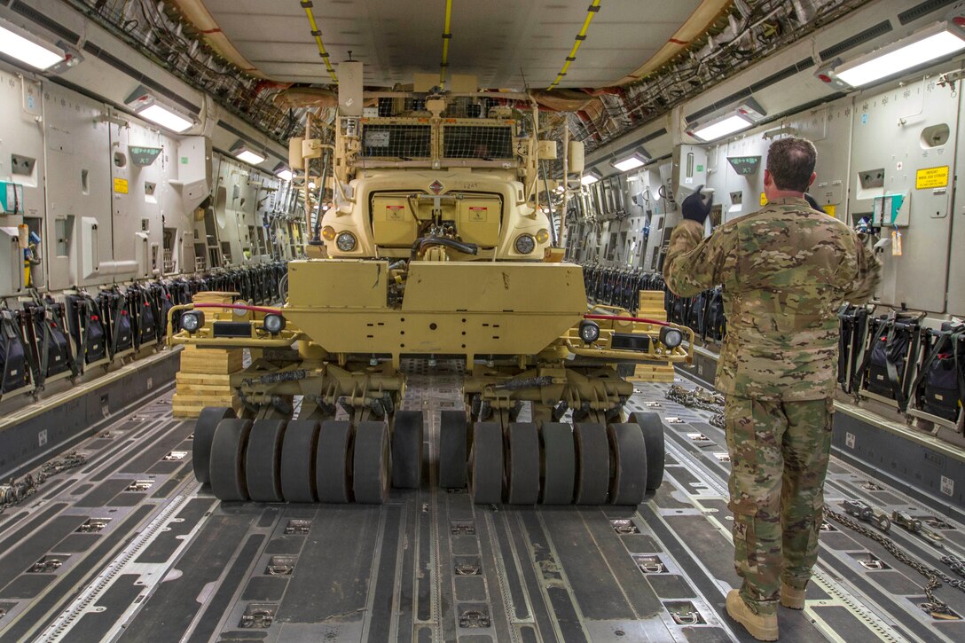 A soldier uses hand signals to guide the driver of a mine-resistant, ambush-protected vehicle into position inside a C-17 Globemaster III at Bagram Airfield, Afghanistan, April 9, 2017. The soldiers are assigned to Company C, 1st Battalion 187th Infantry Regiment. This was the first time an MRAP with a mine sweeper had been loaded on a C-17. Army photo by Sgt. 1st Class Eliodoro Molina