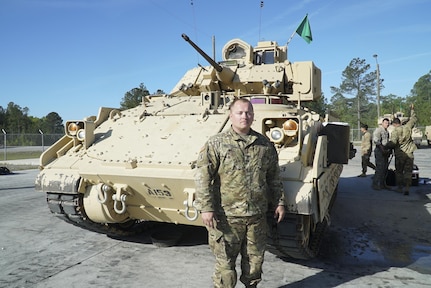 U.S. Army Staff Sgt. Jeffrey Hoffhaus, Company A, 4-118th Combined Arms Battalion, 218th Maneuver Enhancement Brigade, South Carolina National Guard, poses next to his M2 Bradley Infantry Fighting Vehicle during an annual training event at Fort Stewart, Georgia, April 10, 2017. 