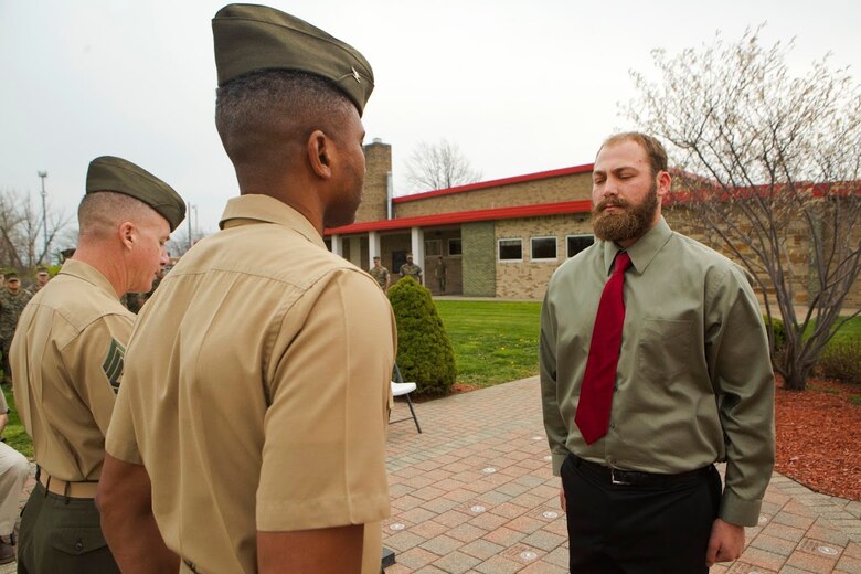 Cpl. Nathan Bryson (right), a Marine Corps veteran who most recently served as a motor transport operator for Headquarters and Support Battalion, School of Infantry East, Camp Lejeune, North Carolina, stands at attention across Col. Ricardo Player (center), the Force Headquarters Group chief of staff, Marine Forces Reserve, while Sgt. Maj. William Grigsby (left), the sergeant major of FHG, MARFORRES, reads off a citation for Bryson’s Navy and Marine Corps Medal ceremony in Brook Park, Ohio, April 13, 2017. In 2014, Bryson and a fellow Marine aided in saving a man from a burning vehicle, risking his life in doing so. The Navy and Marine Corps Medal is awarded for acts of heroism despite personal risk and is the highest honor one can achieve for non-combat service. (U.S. Marine Corps Photo by Cpl. Dallas Johnson/Released)