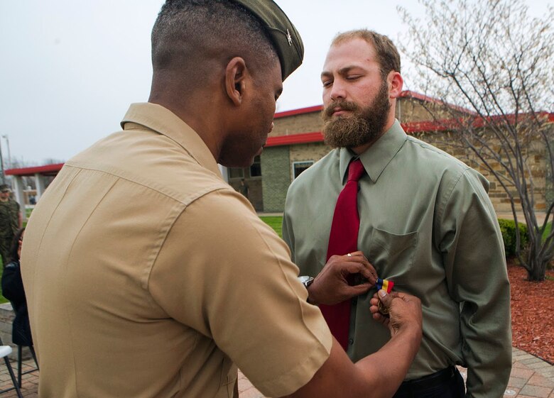 Col. Ricardo Player (left), the Force Headquarters Group chief of staff, Marine Forces Reserve, pins the Navy and Marine Corps Medal on Cpl. Nathan Bryson (right), a Marine Corps veteran who most recently served as a motor transport operator for Headquarters and Support Battalion, School of Infantry East, Camp Lejeune, North Carolina, at the 3rd Battalion, 25th Marine Regiment headquarters in Brook Park, Ohio, April 14, 2017. Bryson was awarded the medal for his actions in 2014 when he and a fellow Marine saved a man from a burning vehicle. The Navy and Marine Corps Medal is awarded for acts of heroism despite personal risk and is the highest honor one can achieve for non-combat service. (U.S. Marine Corps Photo by Cpl. Dallas Johnson/Released)