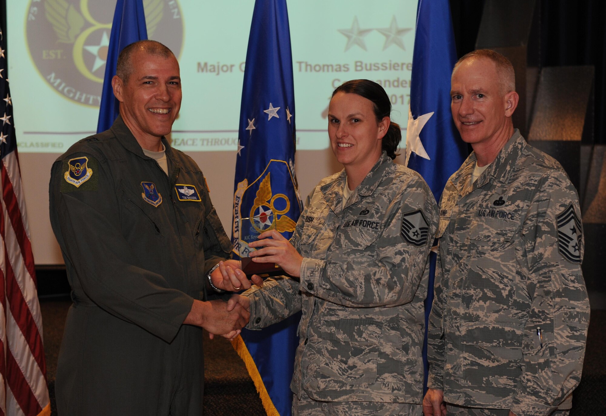 U.S. Air Force Maj. Gen. Thomas Bussiere, Eighth Air Force commander, left, and Chief Master Sgt. Alan Boling, Eighth Air Force command chief, far right, recognizes Airman 1st Class Krystal Cleary, 608th Air Operations Center (not pictured) as a Diamond Sharp Award winner for the month of December during a Headquarters Eighth Air Force commanders call at Barksdale Air Force Base, La., April 12, 2017. Various topics pertinent to the organization were discussed throughout the event, followed by a question and answer engagement session with the Airmen. (U.S. Air Force photo by Senior Airman Erin Trower)