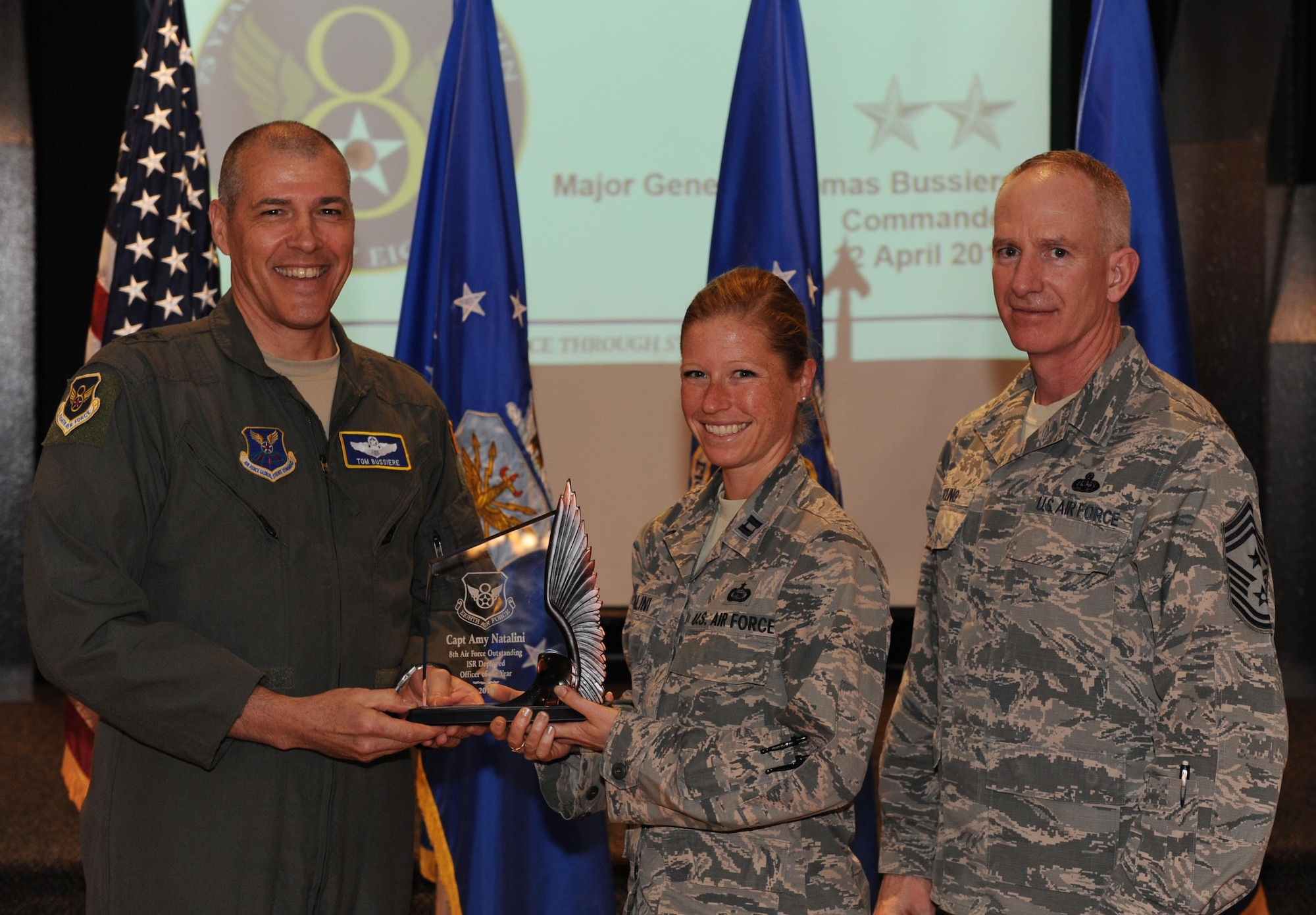 U.S. Air Force Maj. Gen. Thomas Bussiere, Eighth Air Force commander, left, and Chief Master Sgt. Alan Boling, Eighth Air Force command chief, far right, recognizes Capt. Amy Natalini as the Eighth Air Force’s Outstanding ISR Deployed Officer of the Year during a Headquarters Eighth Air Force commanders call at Barksdale Air Force Base, La., April 12, 2017. Various topics pertinent to the organization were discussed throughout the event, followed by a question and answer engagement session with the Airmen. (U.S. Air Force photo by Senior Airman Erin Trower)