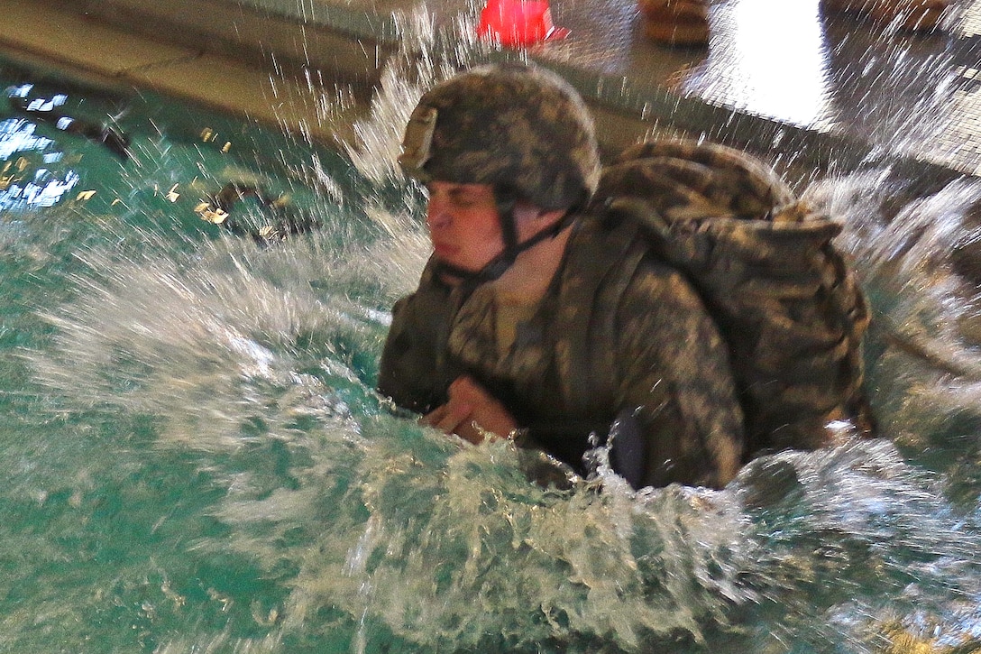 A soldier takes a plunge into the pool to participate in combat water survival training at Virginia Beach, Va., April 8, 2017. Army National Guard photo by Sgt. Amanda H. Johnson