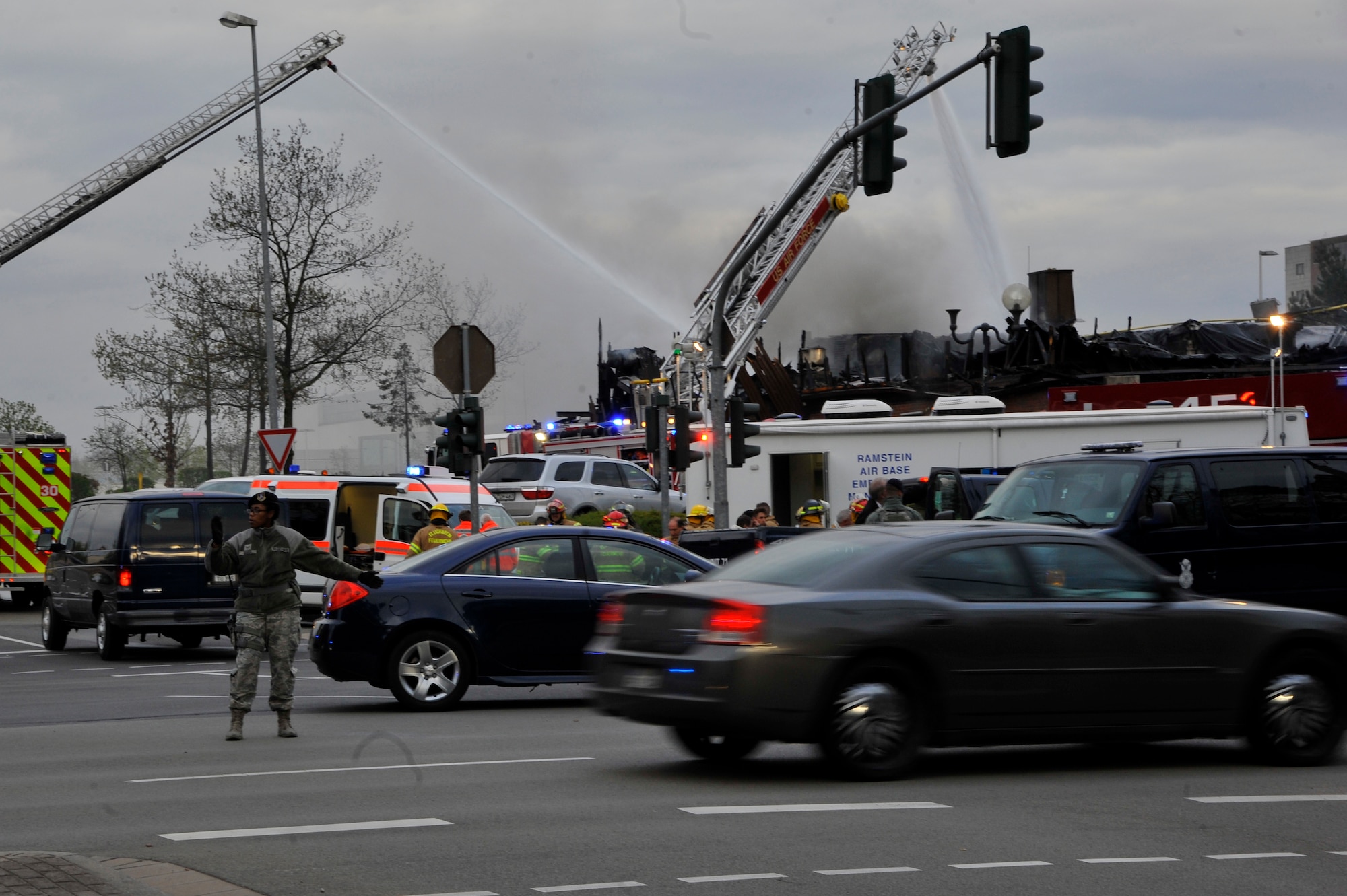 Airmen direct traffic at the scene of a fire at bldg. 1135, April 16, 2017 on Ramstein Air Base, Germany. According to base officials, the fire was contained and there was one minor injury, of a firefighter. The cause of the incident is under investigation. (U.S. Air Force photo by Airmen 1st Class D. Blake Browning)