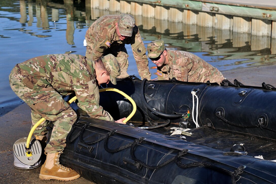 Soldiers remove water from a rubber craft after participating in combat rubber raiding craft familiarization at Virginia Beach, Va., April 9, 2017. Army National Guard photo by Sgt. Amanda H. Johnson