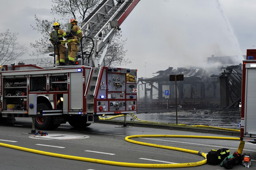 86th Civil Engineer Group Airmen operate an extendable ladder outside of a fire at bldg. 1135, April 16, 2017 on Ramstein Air Base, Germany. According to base officials, the fire was contained and there was one minor injury, of a firefighter. The cause of the incident is under investigation. (U.S. Air Force photo by Airmen 1st Class D. Blake Browning)
