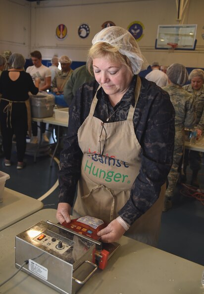 Thea Wasche, 50th Force Support Squadron deputy command, seals bags of rice during the Kids Against Hunger volunteer event at Schriever Air Force Base, Colorado, Tuesday, April 11, 2017. The mission of KAH, a humanitarian food-aid organization incorporated in 1999, is to significantly reduce the number of hungry children in the United States and to feed starving children throughout the world. (Air Force photo/Senior Airman Arielle Vasquez)