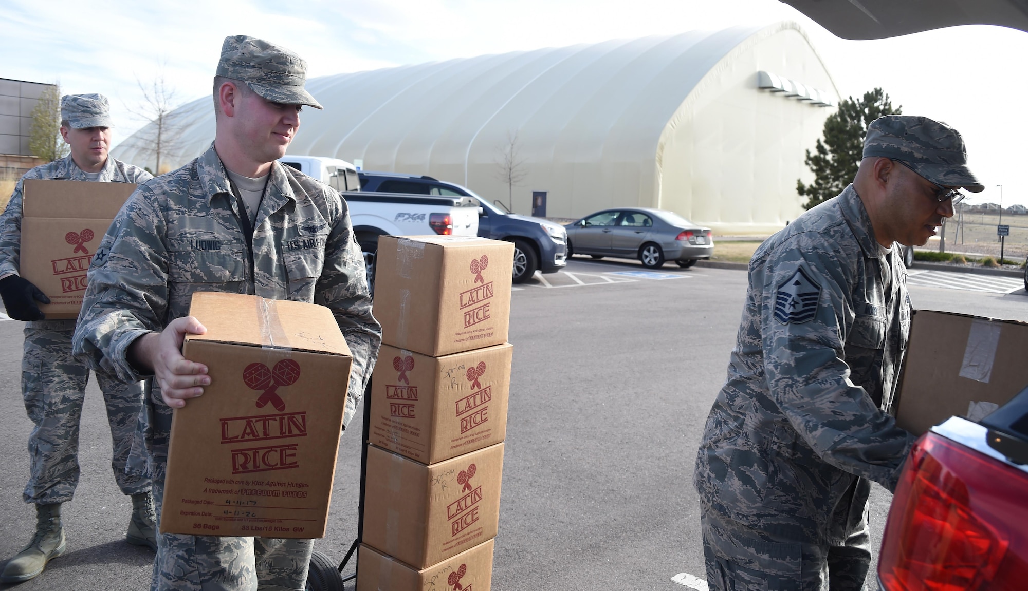 Master Sgt. Chad Peterson, 50th Security Forces Squadron first sergeant, Airman 1st Class Spencer Ludwig, 4th Space Operations Squadron and Master Sgt. Gerald Morey, 21st Comptroller Squadron first sergeant, load boxes of food into a vehicle at Schriever Air Force Base, Colorado, Wednesday, April 12, 2017. First Sergeants from Schriever AFB, Peterson AFB and Cheyenne Mountain Air Force Station delivered the food packages the following day to Ellicott and Peterson feeder schools as well as the Care and Share Food Banks. (Air Force photo/Senior Airman Arielle Vasquez)