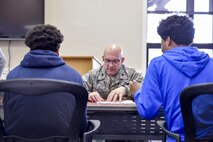 Lt. Col. John Kochansky, director of inspections with the 910th Inspector General office, helps Inspiring Minds students with schoolwork during a study and tutoring session April 13, 2017. Youngstown Air Reserve Station partners with Inspiring Minds, a non-profit K-12 youth organization based in Warren, Ohio, to provide mentorship and represent the Air Force Reserve as a career option. Volunteers from YARS devote personal time to mentorship, tutoring and fun activities with the students several times throughout the school year. (U.S. Air Force photo/Eric White)