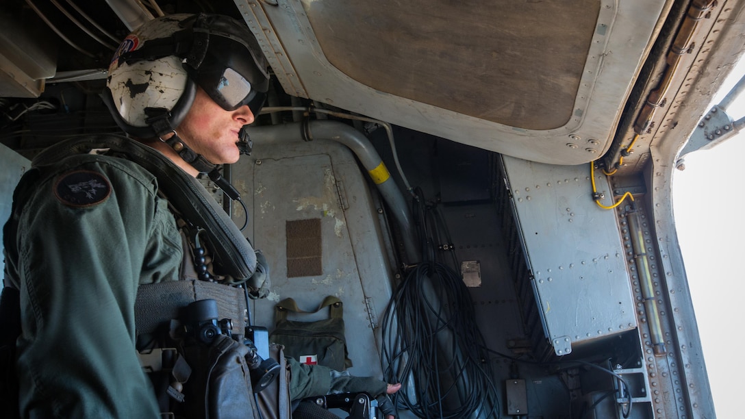 Marine Corps Cpl. Bradley Lauer, a crew chief with Marine Heavy Helicopter Squadron 466, looks out of a gunner's window during a tactical support insert and extract exercise in part of Weapons and Tactics Instructors course 2-17 at Naval Air Facility El Centro, Calif., April 15, 2017. WTI is held biannually at Marine Corps Air Station Yuma, Ariz. to provide students with detailed training to be practiced on the various ranges in Arizona and California.