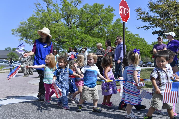 Members of Team Charleston from the Childcare Development Center hold up signs during a parade here for a Month of the Military Child celebration, April 14, 2017. April is designated as Month of the Military Child to recognize the 1.7 million military children across the globe and the sacrifices they make alongside their parents. 