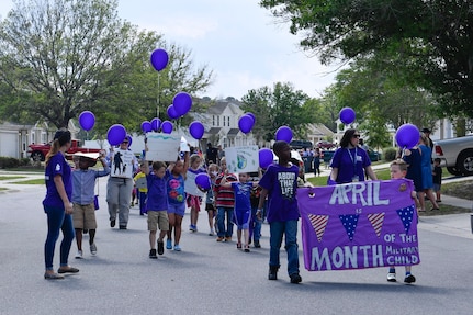 Members of Team Charleston from the Childcare Development Center hold up signs during a parade here for a Month of the Military Child celebration, April 14, 2017. April is designated as Month of the Military Child to recognize the 1.7 million military children across the globe and the sacrifices they make alongside their parents. 