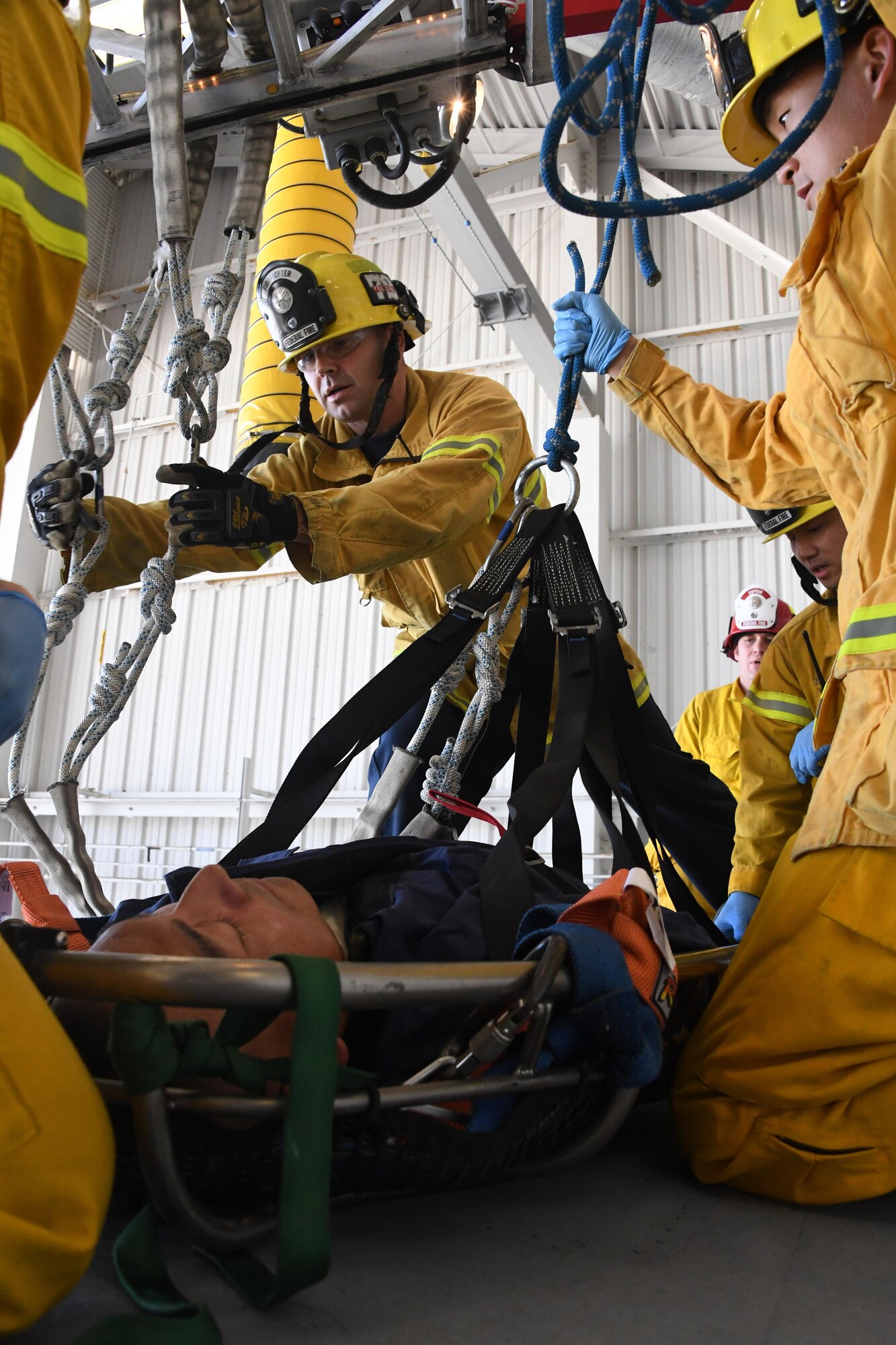 Federal Fire Ventura County Firefighter Michael Barnett and Firefighter David Yi prepare a transport litter stretcher to lower Senior Airman Pedro Pescador with the 146th Airlift Wing’s Aircraft Fuel Systems Maintenance Squadron off the wing of a C-130J aircraft during a “confined space rescue exercise” at the Channel Islands Air National Guard Station Port Hueneme, Calif. April 1, 2017. During a confined space rescue exercise, first-responders with the 146th Airlift Wing’s Aircraft Fuel Systems Maintenance Squadron and Federal Fire Ventura County firefighters run through the critical emergency operations that would take place if a fuel-cell maintenance worker were to become incapacitated while working inside the very small fuel tanks inside the aircraft’s wings. (U.S. Air National Guard photo by: Staff Sgt. Nieko Carzis.)