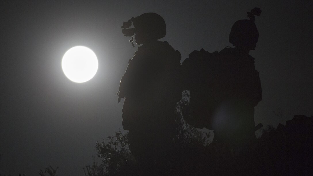 Marine Corps Capt. David Hirt, left, and Maj. Stephen Piantarnida observe the terrain using night-vision goggles during an air support exercise as part of a weapons and tactics course for instructors at Chocolate Mountain Aerial Gunnery Range, Ariz., April 11, 2017. The training emphasizes operational integration of the six functions of Marine Corps aviation to support a Marine Air Ground Task Force. Marine Corps photo by Cpl. Aaron James Vinculado